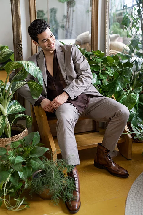 Male coach or consultant seated in a plant-filled interior during a professional personal branding session