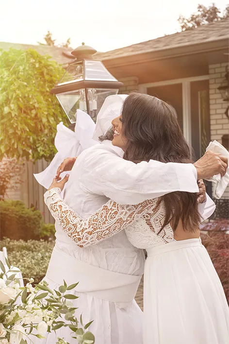 Two women embracing during an outdoor family or milestone celebration