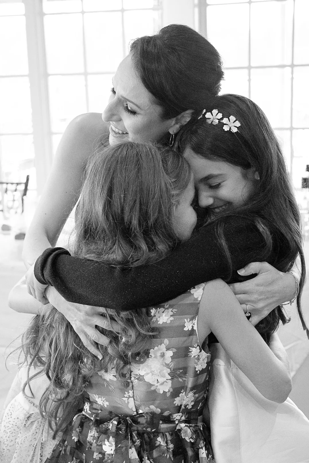 Black and white photograph of family members embracing during an emotional candid moment