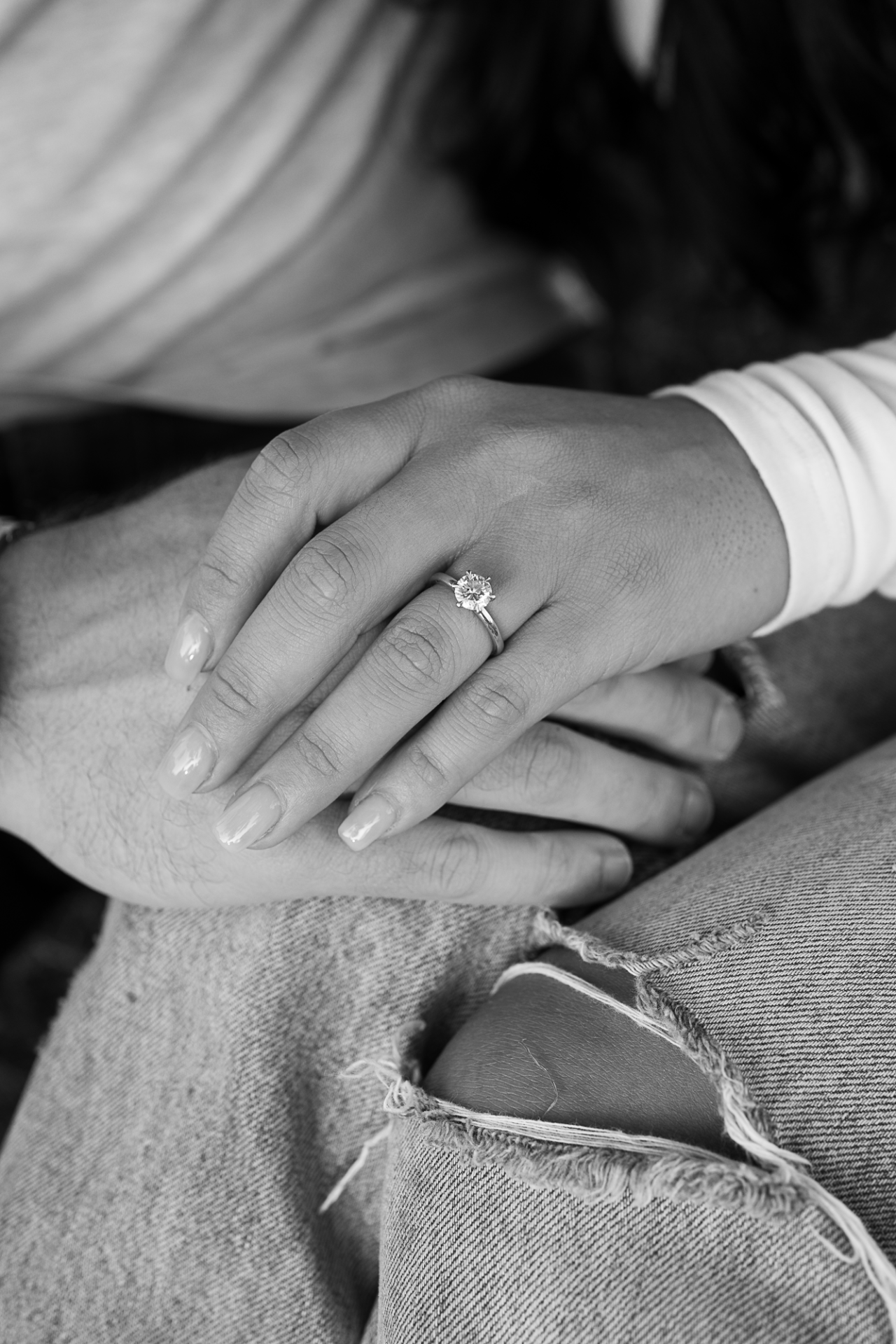Black and white close-up of an engagement ring and hands during a couples photography session