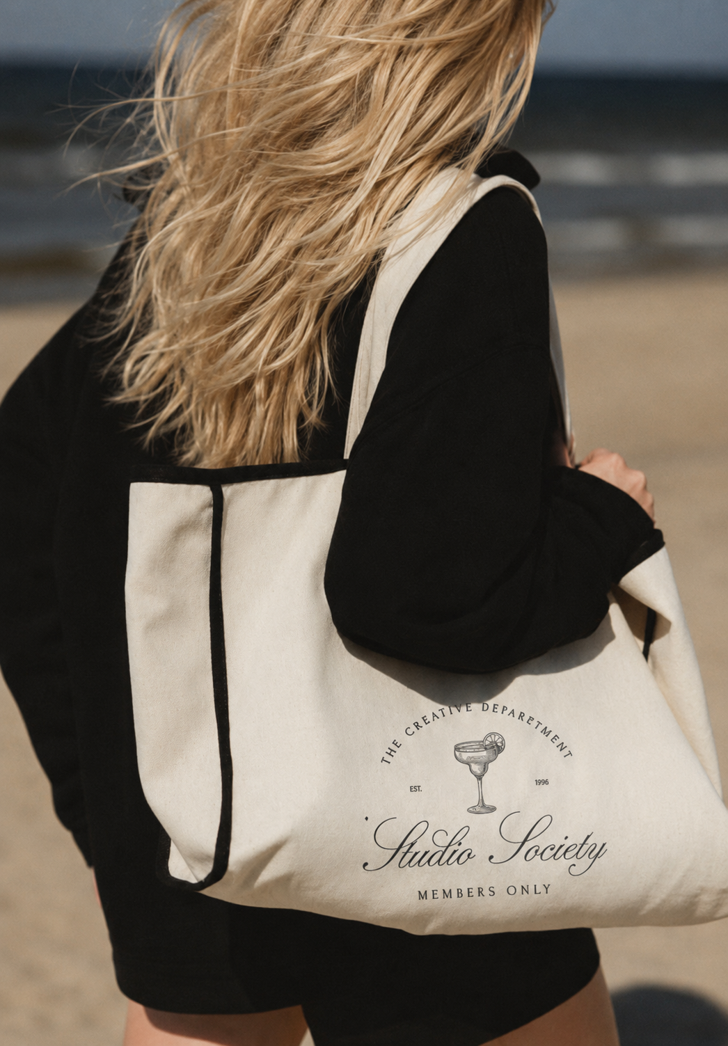 Woman walking at beach with Company bag merch during a lifestyle branding photography session