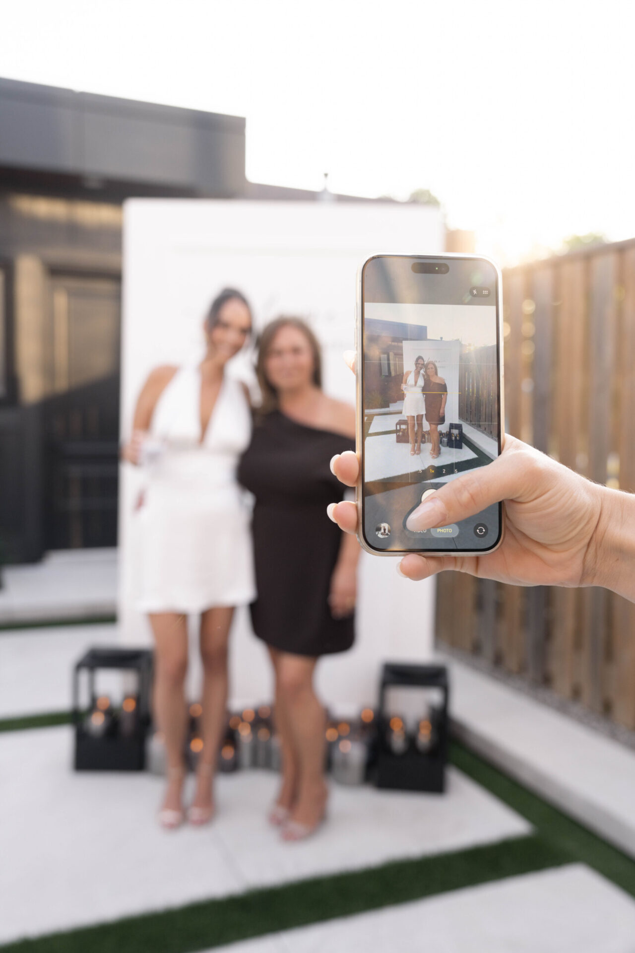 Smartphone capturing two women posing together during an event or celebration