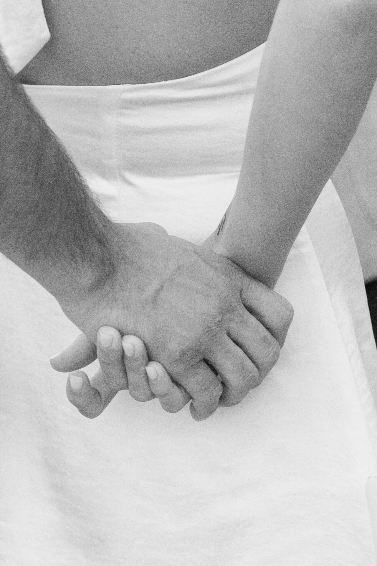 Black and white close-up of a couple holding hands during a lifestyle photography session