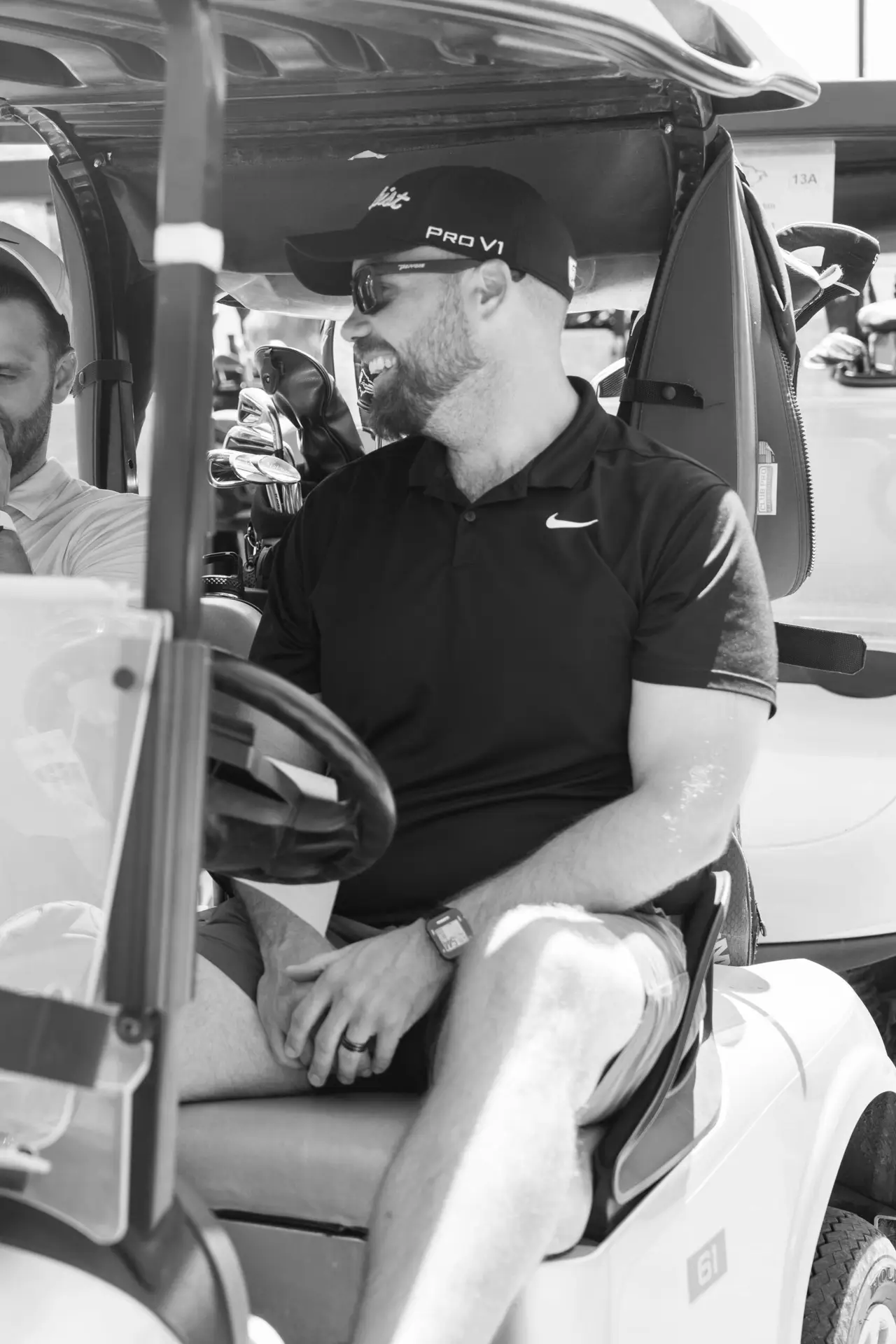 Black and white candid portrait of a smiling man seated during an event