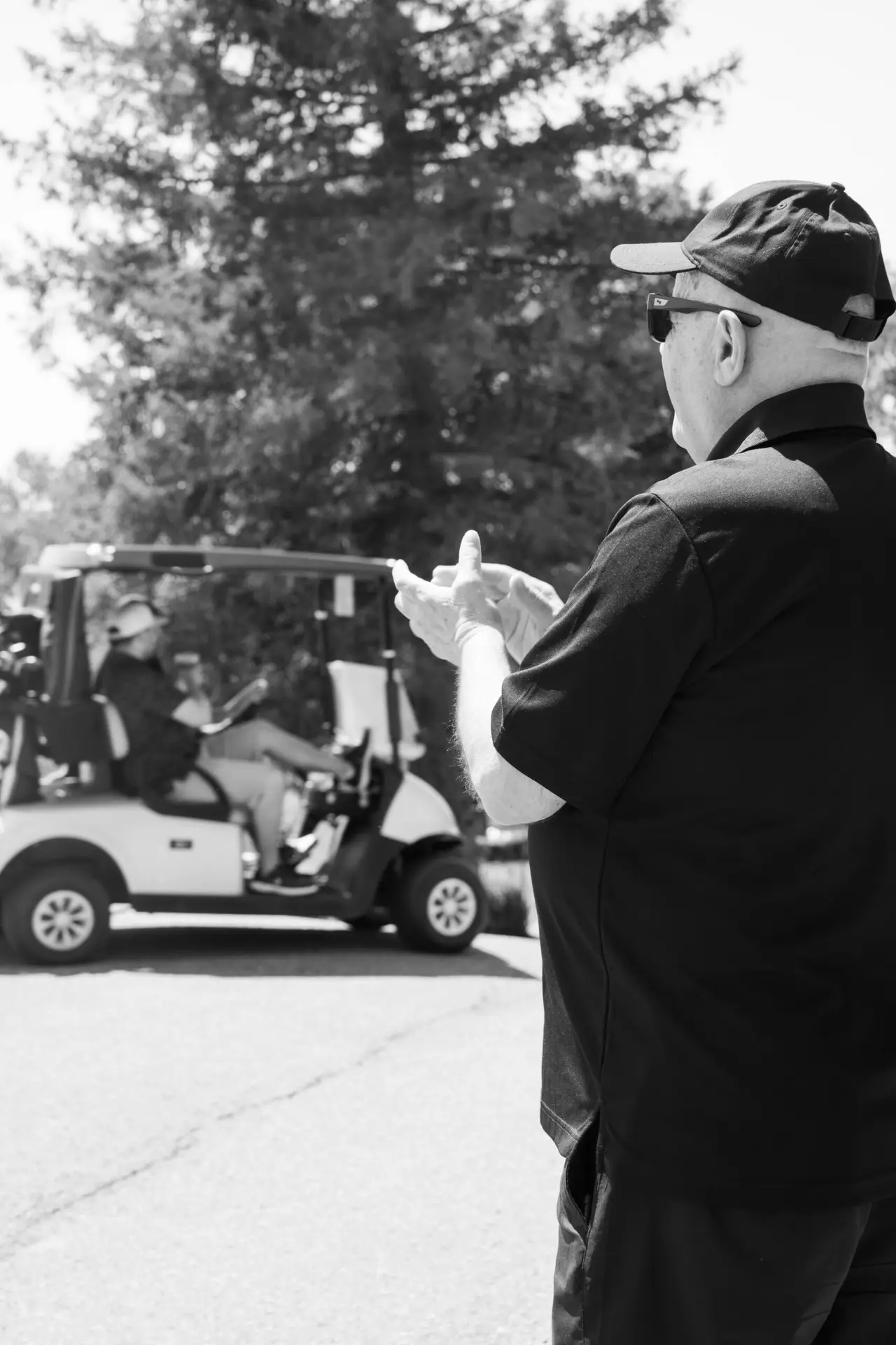 Black and white candid photograph of guests during an outdoor celebration
